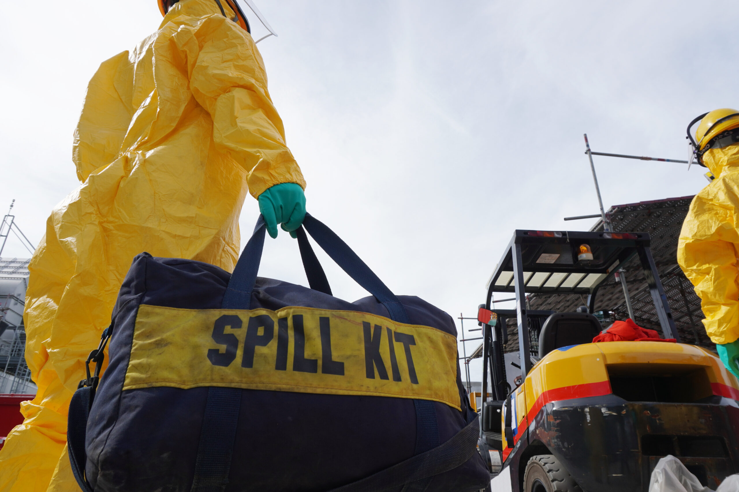 Rescue personnel wear yellow chemical protective clothing during