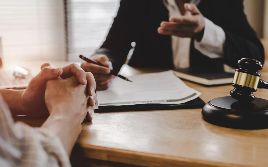 An attorney sitting at his desk speaking to a client about their claim.