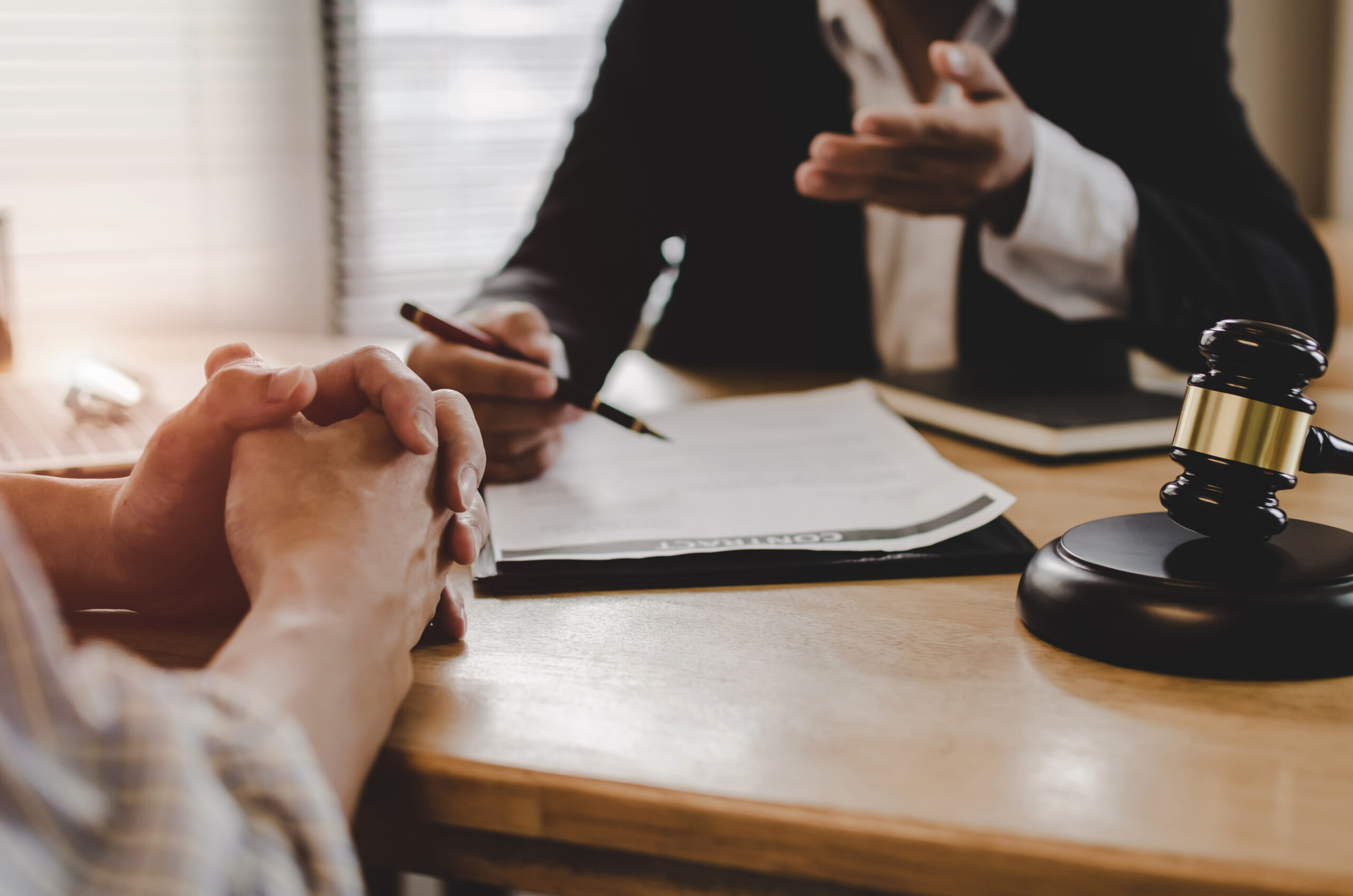 An attorney sitting at his desk speaking to a client about their claim.