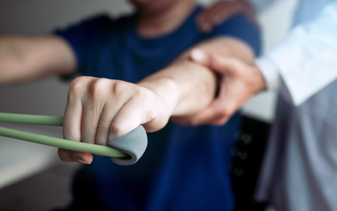 person in physical therapy being assisted with strength exercise