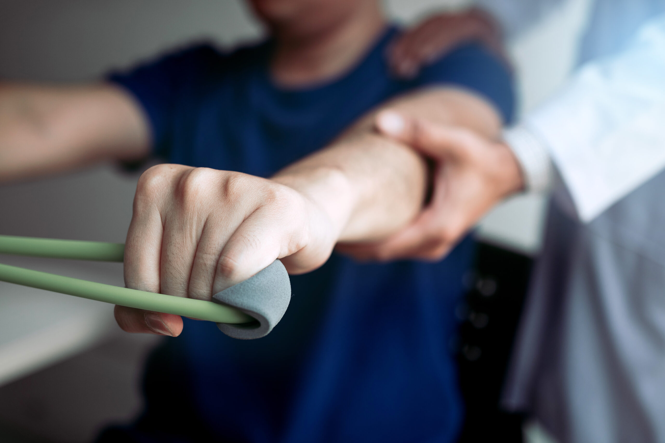 person in physical therapy being assisted with strength exercise