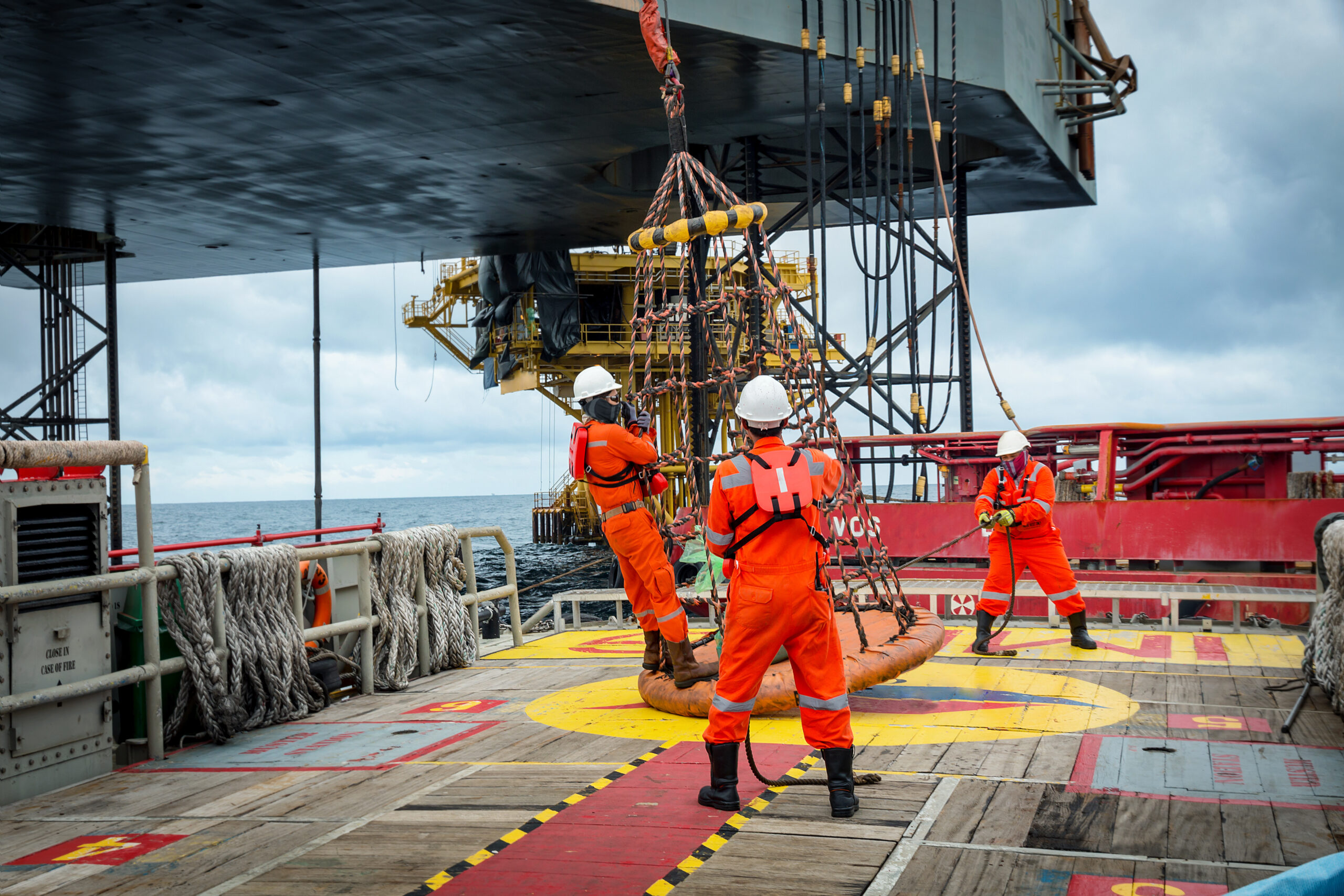 oil rig workers handling equipment