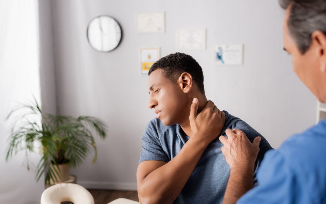 injured african american man touching neck