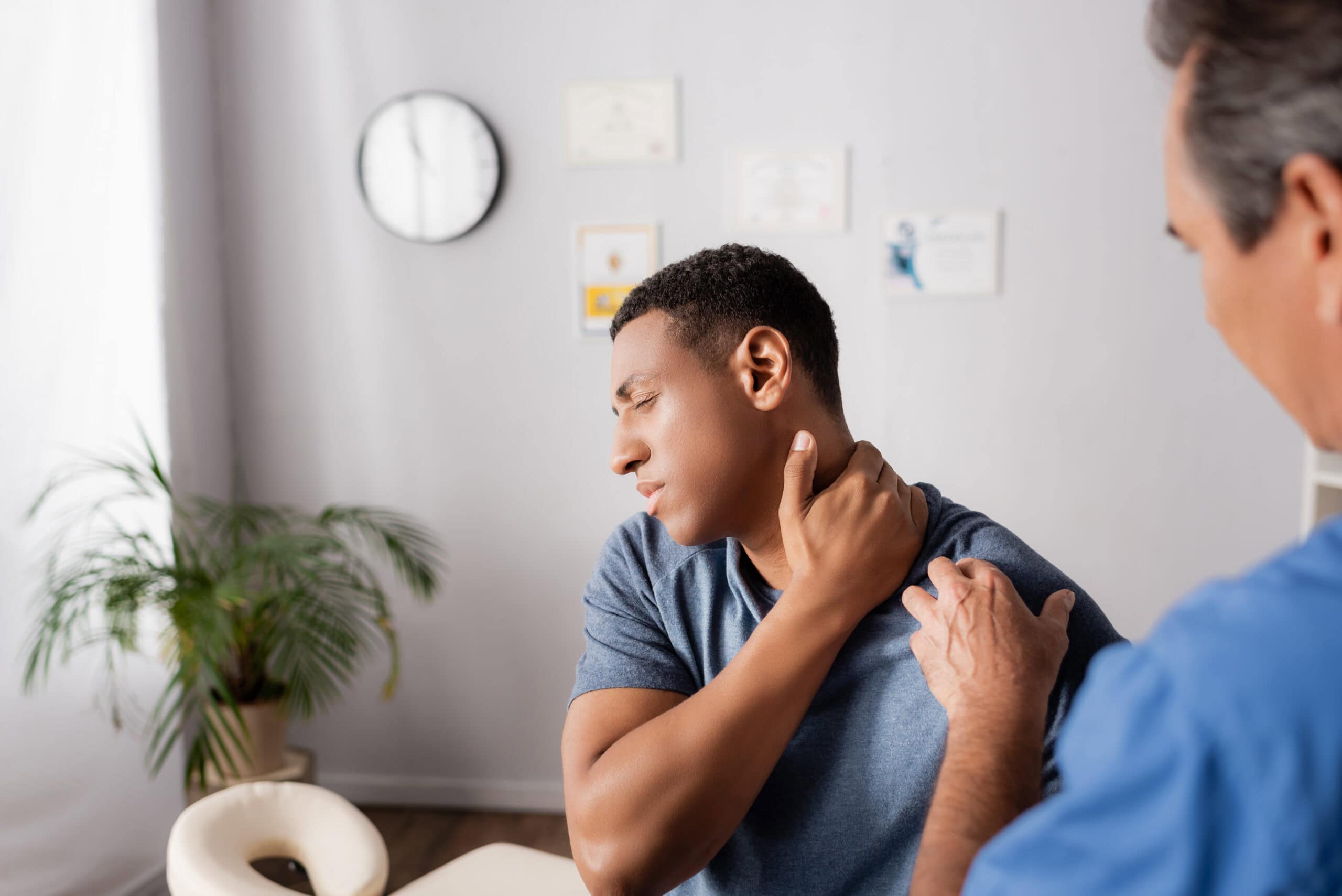 injured african american man touching neck