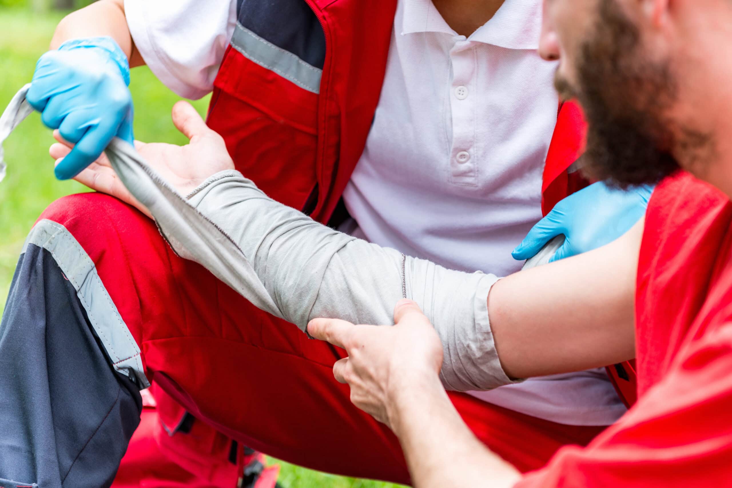 Medical worker treating burns on male's hand.