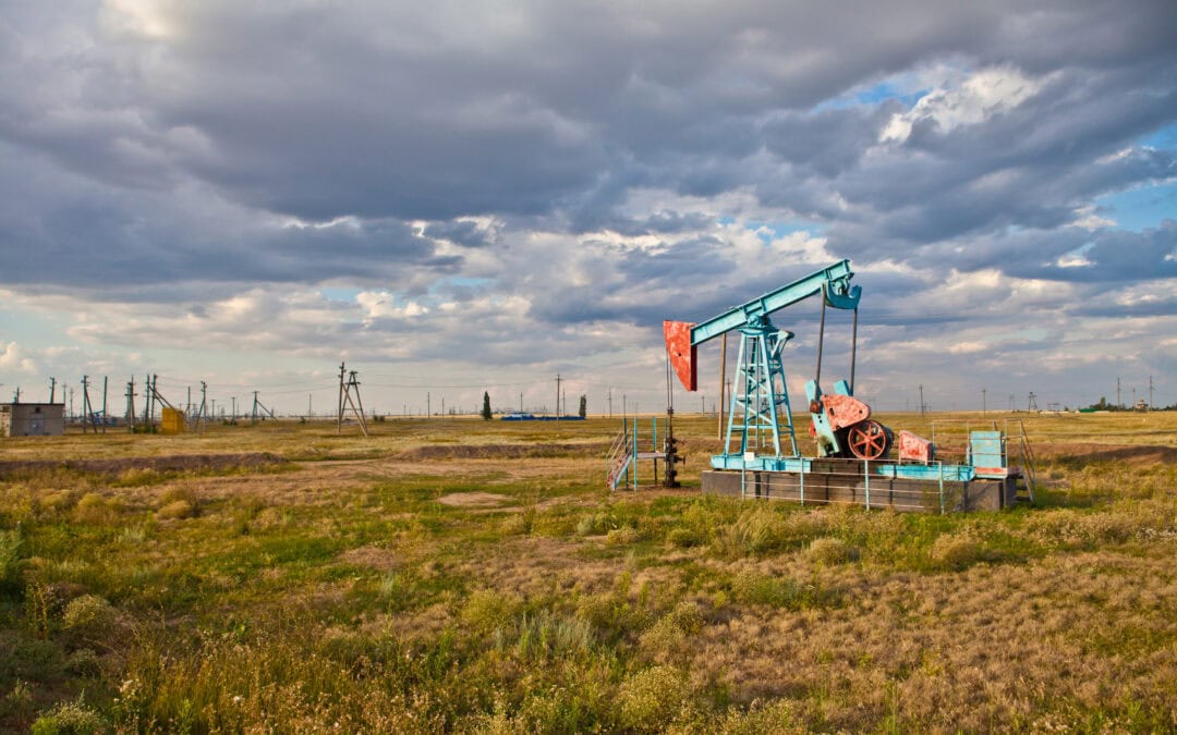 Oil pump in the field on a background cloudy sky