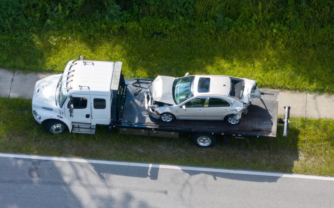 Car crash site with tow truck loading destroyed vehicle after truck accident