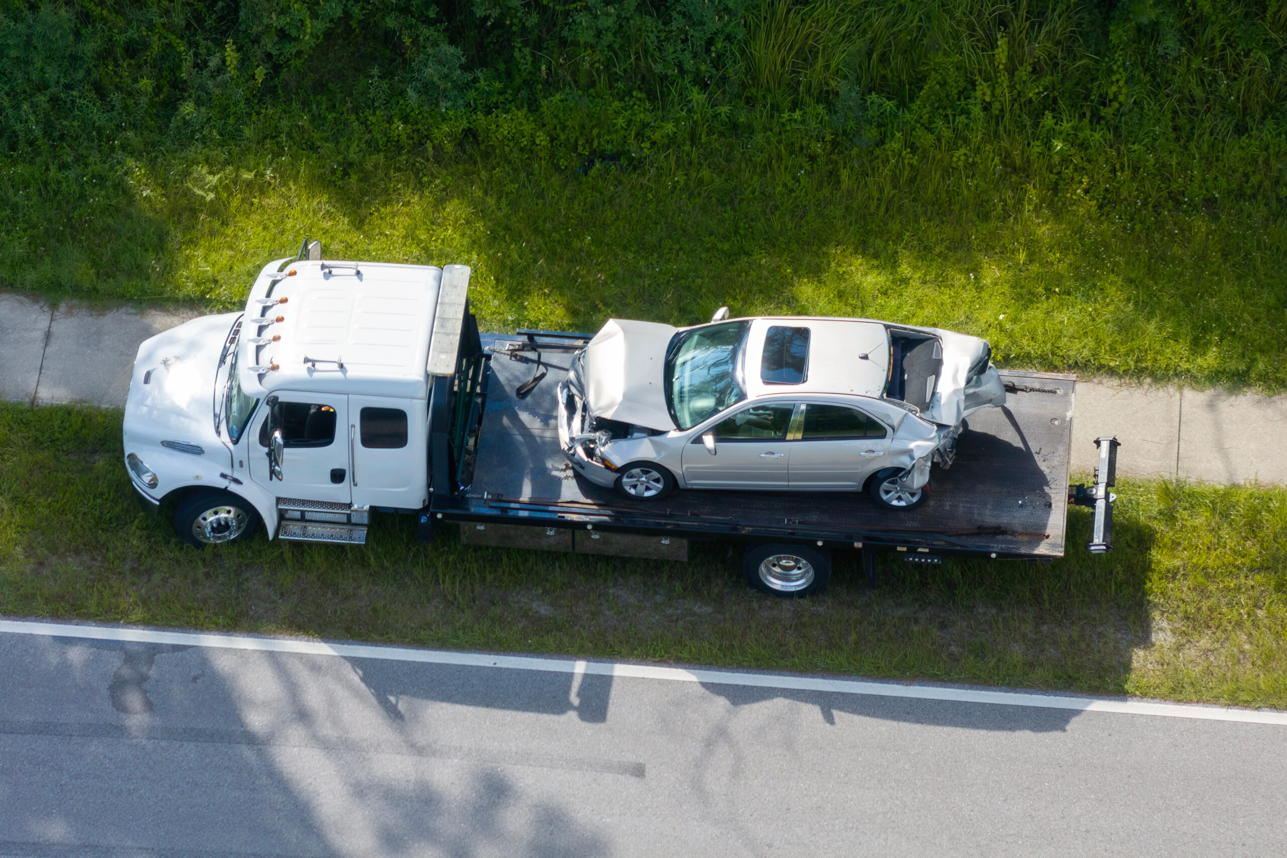 Car crash site with tow truck loading destroyed vehicle after truck accident