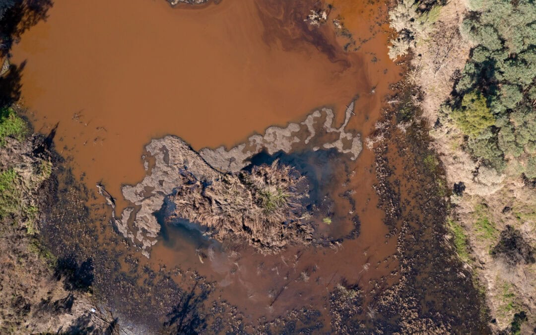 Drone aerial photograph of a polluted small overflow reservoir after severe flooding