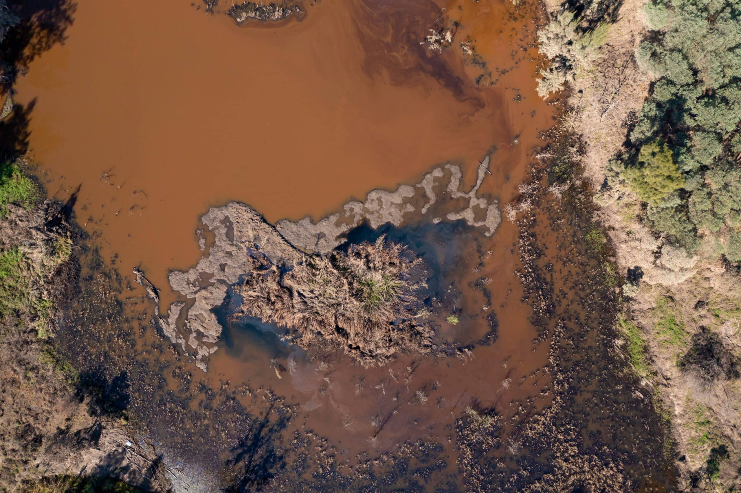 Drone aerial photograph of a polluted small overflow reservoir after severe flooding