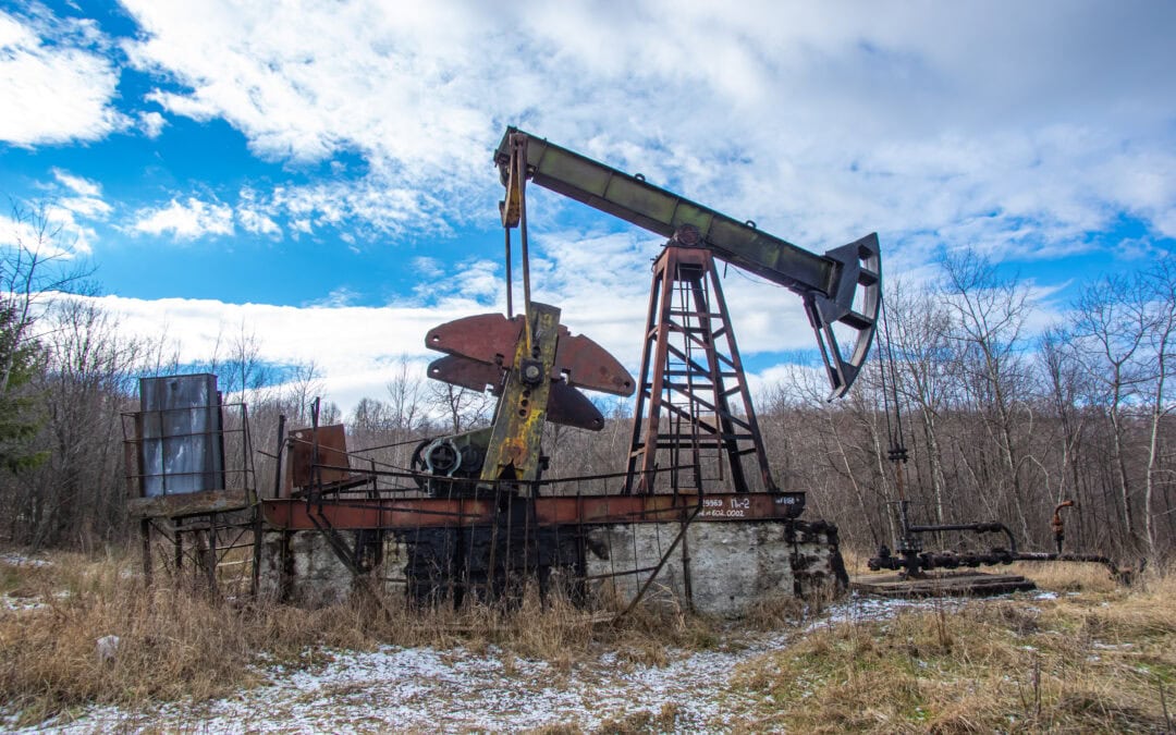 Old abandoned oil pump in the middle of the forest