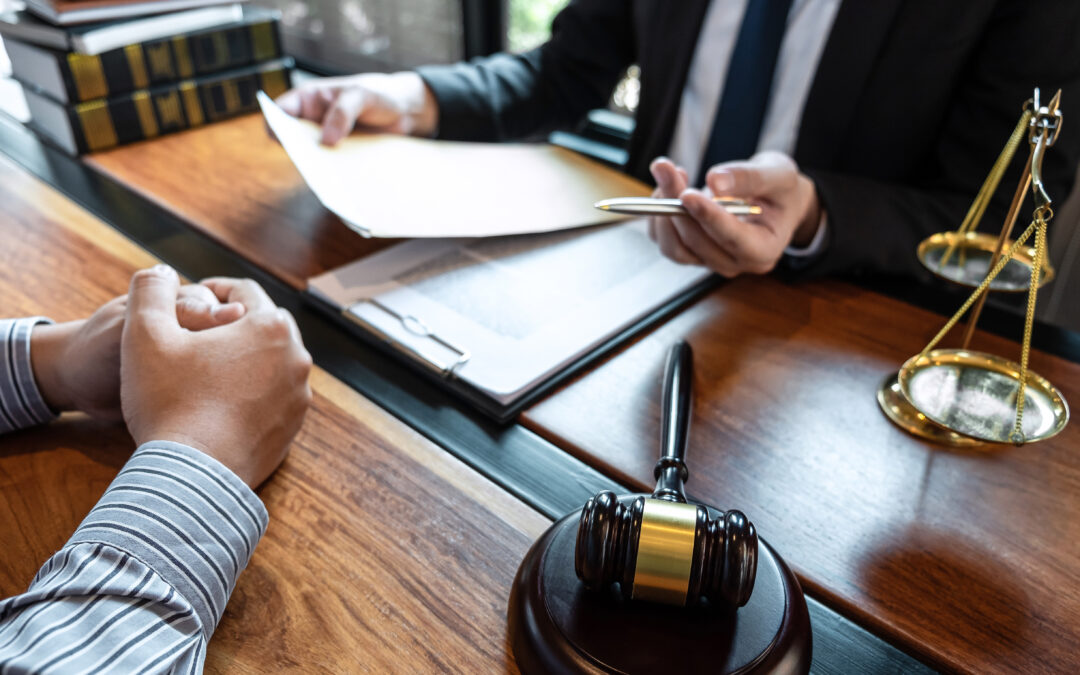 attorney discussing case with client meeting with document contact in courtroom