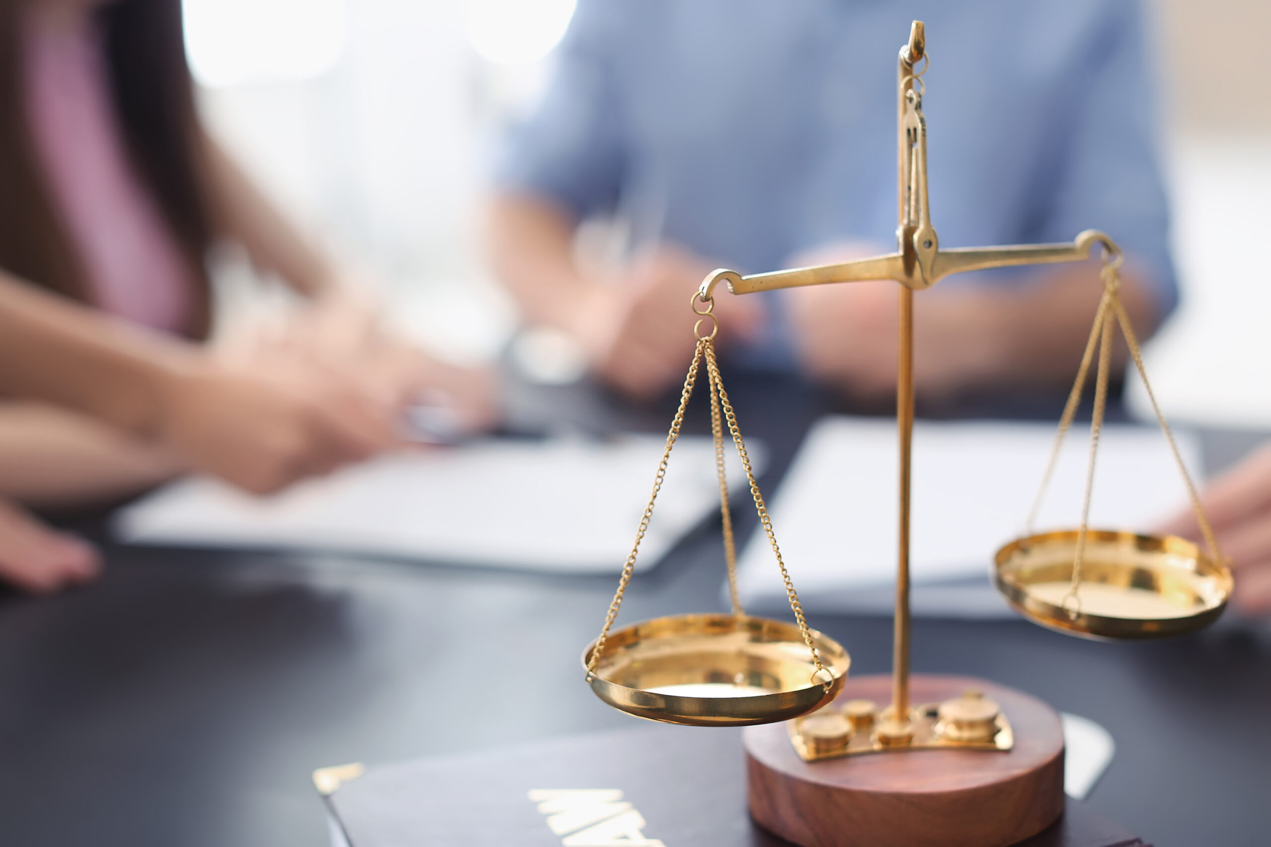 Scales of justice with juridical book on table in lawyer’s office scales of justice on attorney's desk as they meet with clients